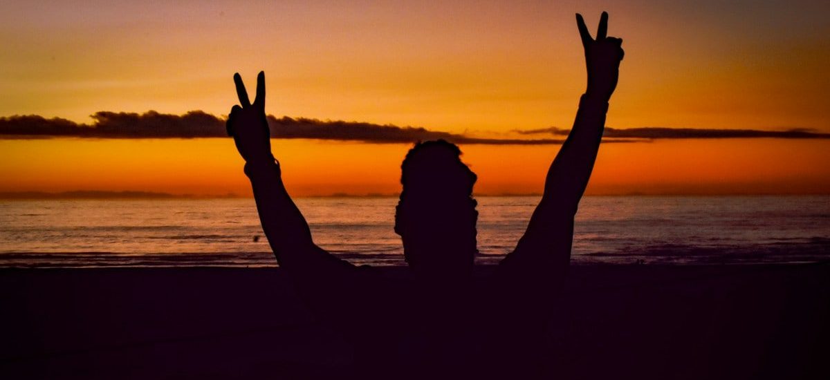 a person on a beach with their hands in the air