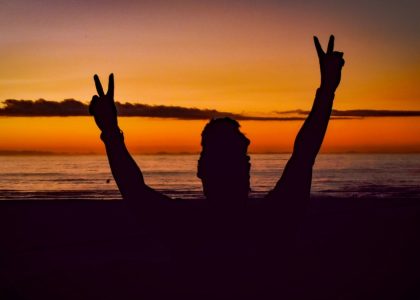 a person on a beach with their hands in the air